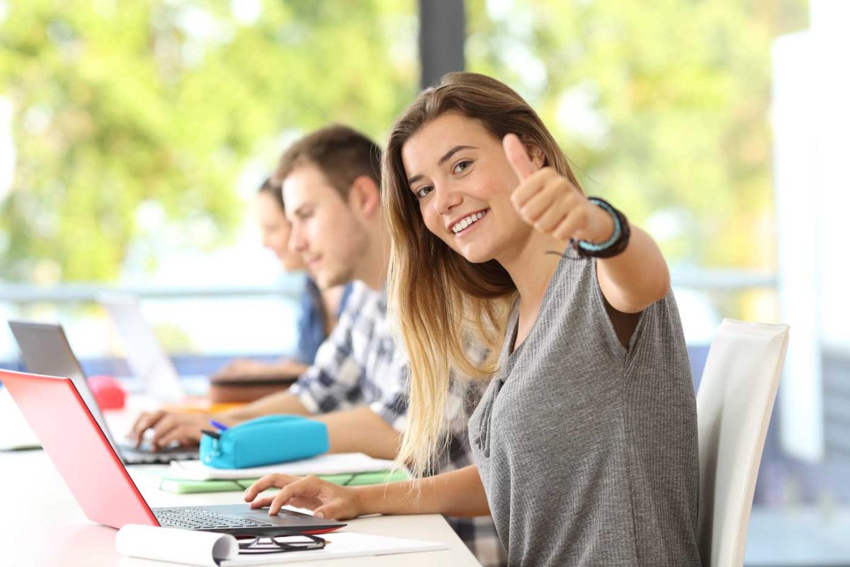 Birte Struntz Seminare Seminarraum. Im Vordergrund Frau am Laptop mit Daumen hoch