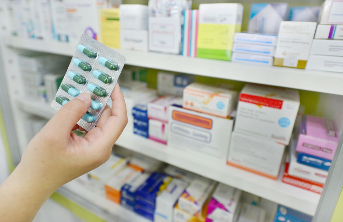 Hand nimmt Tabletten aus einem Tablettenschrank. Hand nimmt Tabletten aus einem Tablettenschrank.