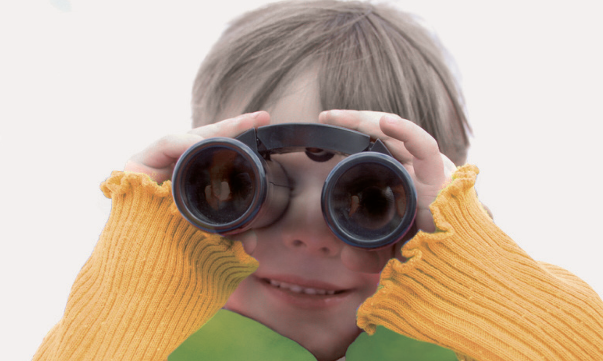 Kind hält sich ein Fernglas vor die Augen