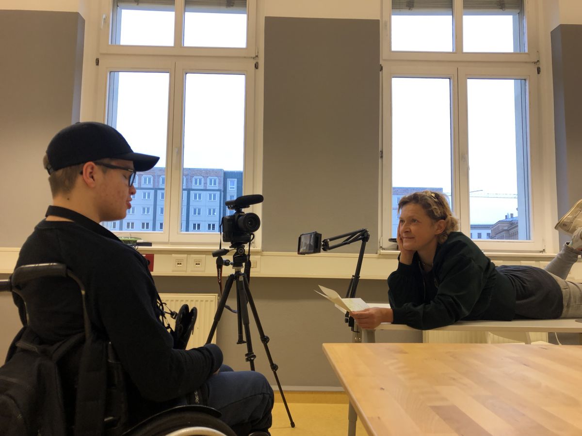 Frau interviewed Jungen im Rollstuhl. Frau interviewed Jungen im Rollstuhl.