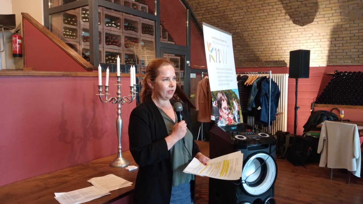 Kathrin Jackel-Neusser mit einem Mikrophon in der Hand, während sie referiert. Kathrin Jackel-Neusser mit einem Mikrophon in der Hand, während sie referiert.
