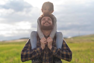 Vater mit Sohn auf einer Wiese.